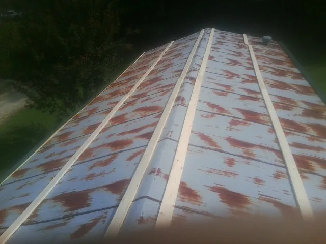Rusted metal roof panels with new wood purlins before replacement — Storm Damage Roof Repair in West Alexander by Roofing Brothers
