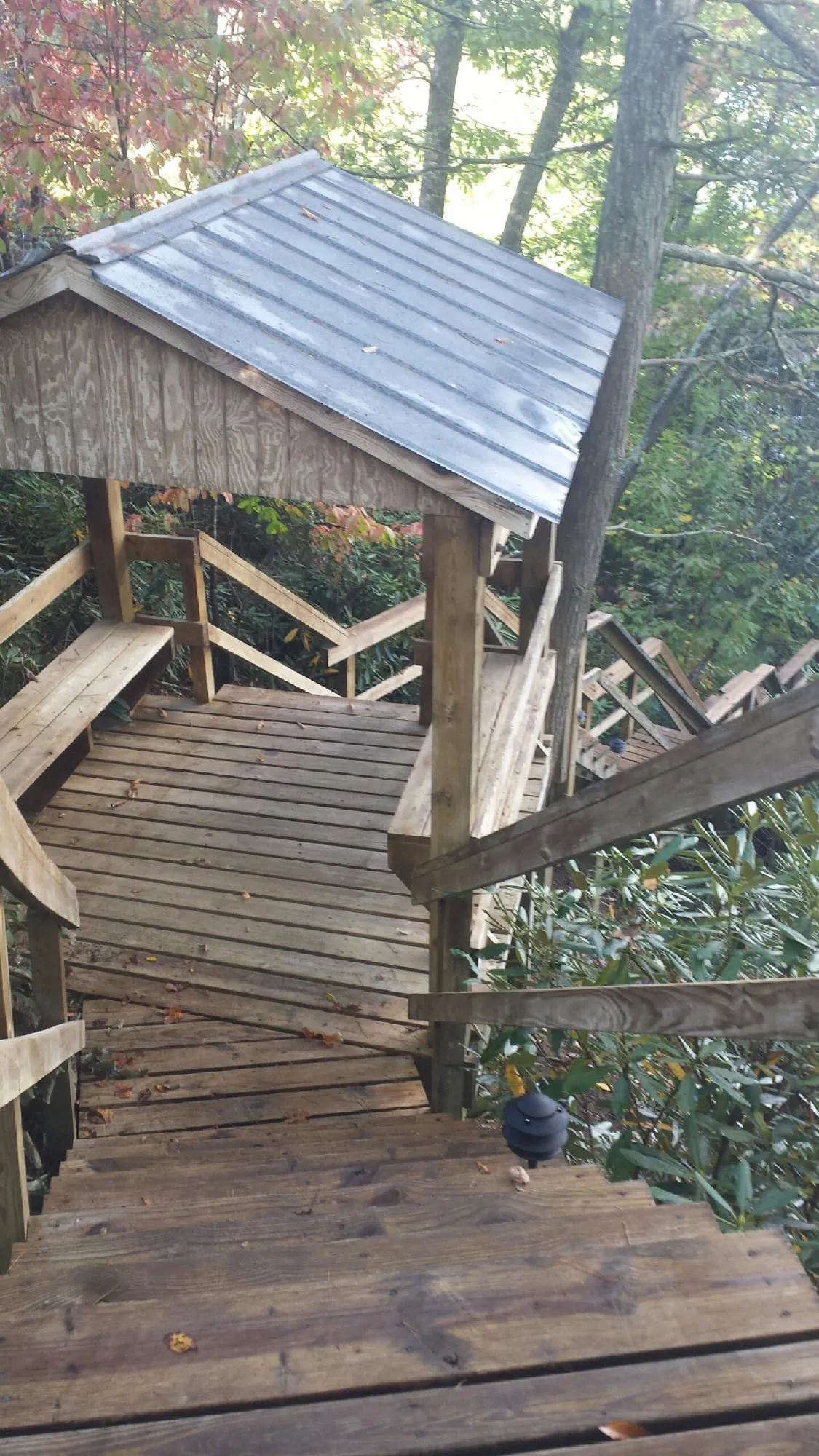 Metal roofed shelter over wooden steps on a wooded walkway — Skylight Repair & Installation work by our crew in West Alexander