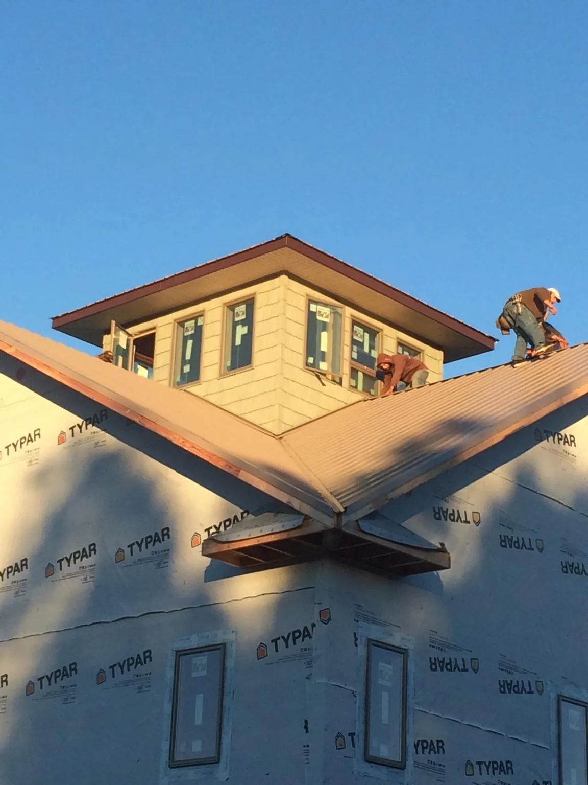 Roofers working around a rooftop cupola on a new metal roof at sunset — Roof Waterproofing in West Alexander by Roofing Brothers